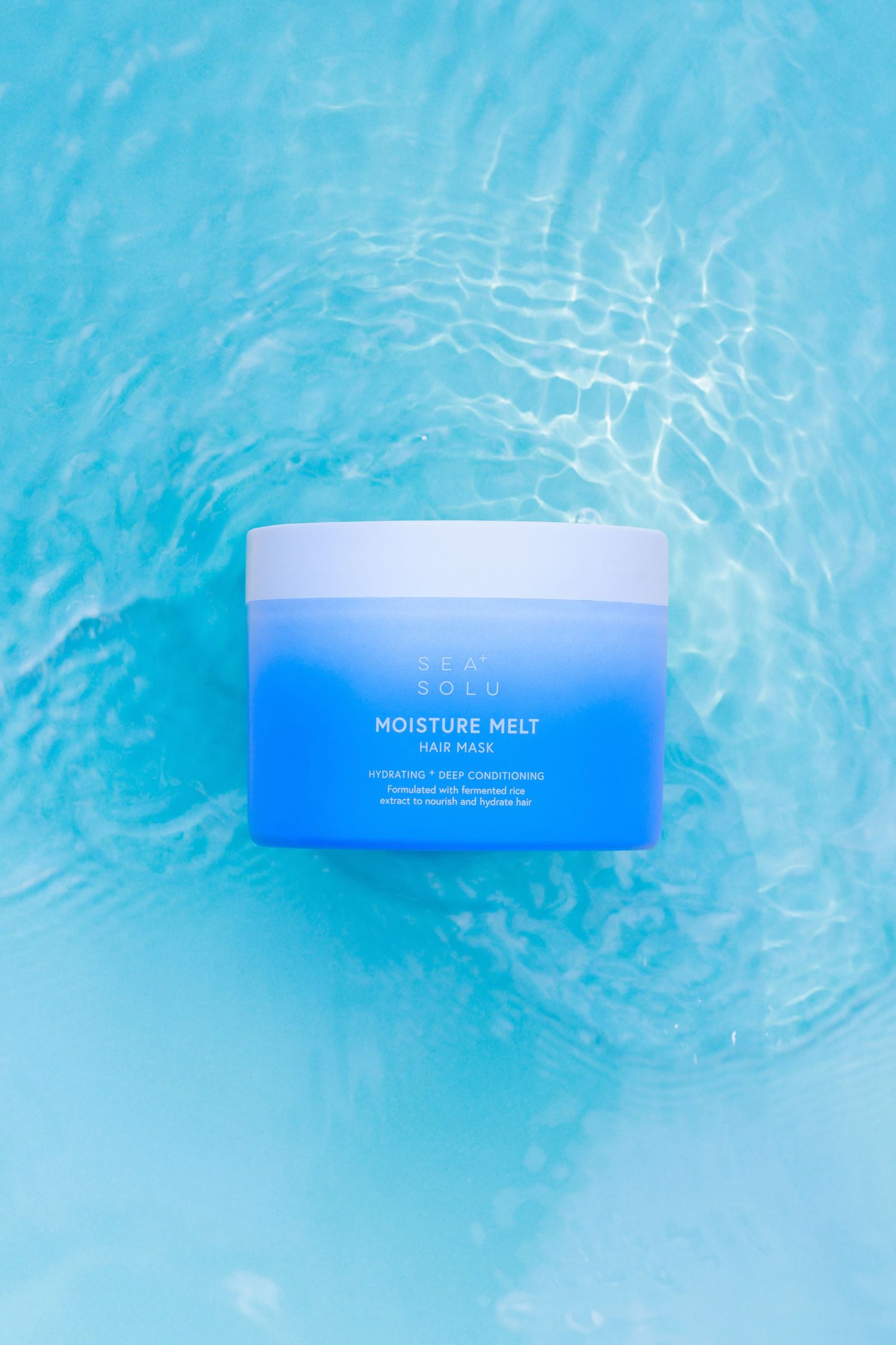 Blue hair mask floating on rippling blue water surface creating reflective patterns.