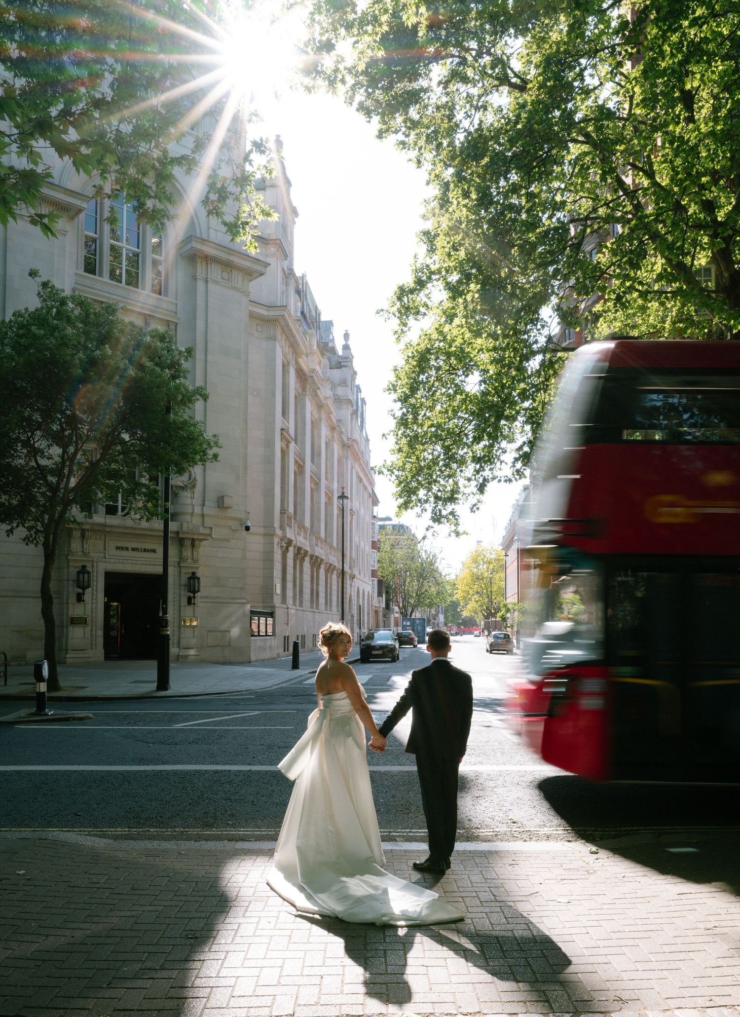 A sequence of wedding photos shows a couple and a red bus passing by on a tree-lined London city street in natural lighting.