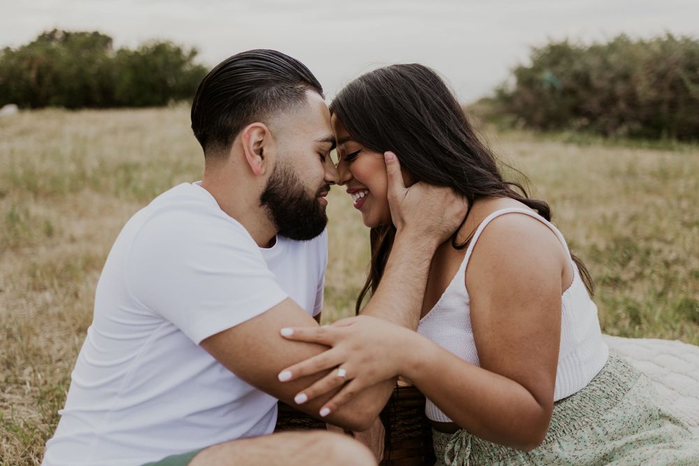 Intimate close-up of couple sharing romantic moment in grassy field.