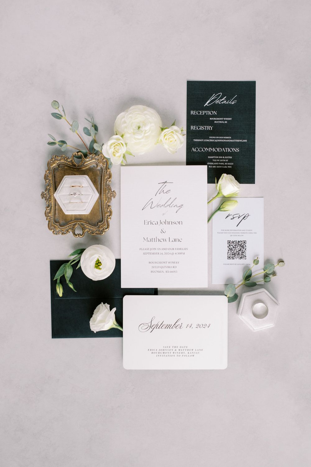 Elegant white and dark green wedding invitation suite with gold accents and white floral details on gray background.