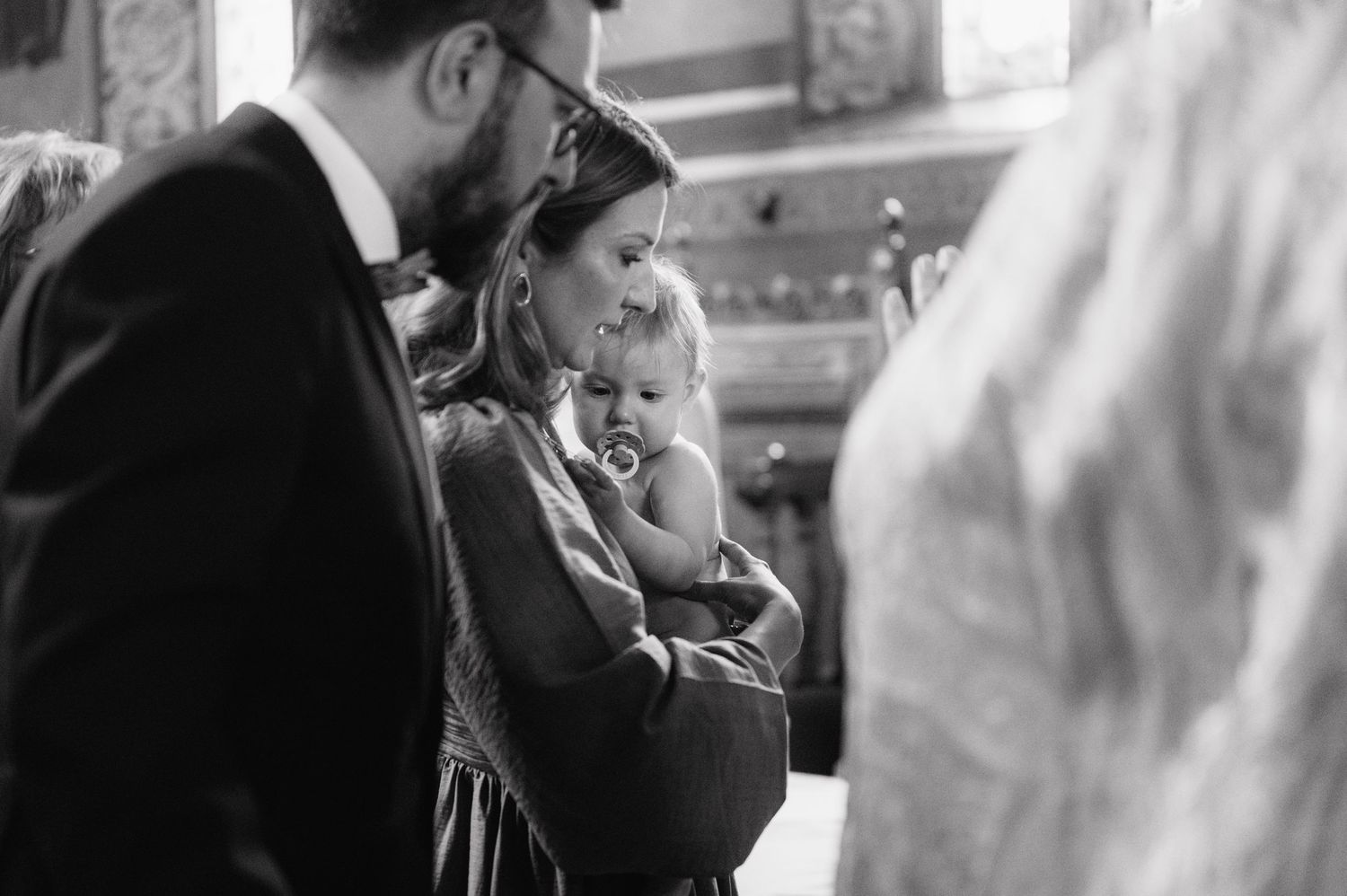 A black and white photograph of a warm family moment together at an indoor event.