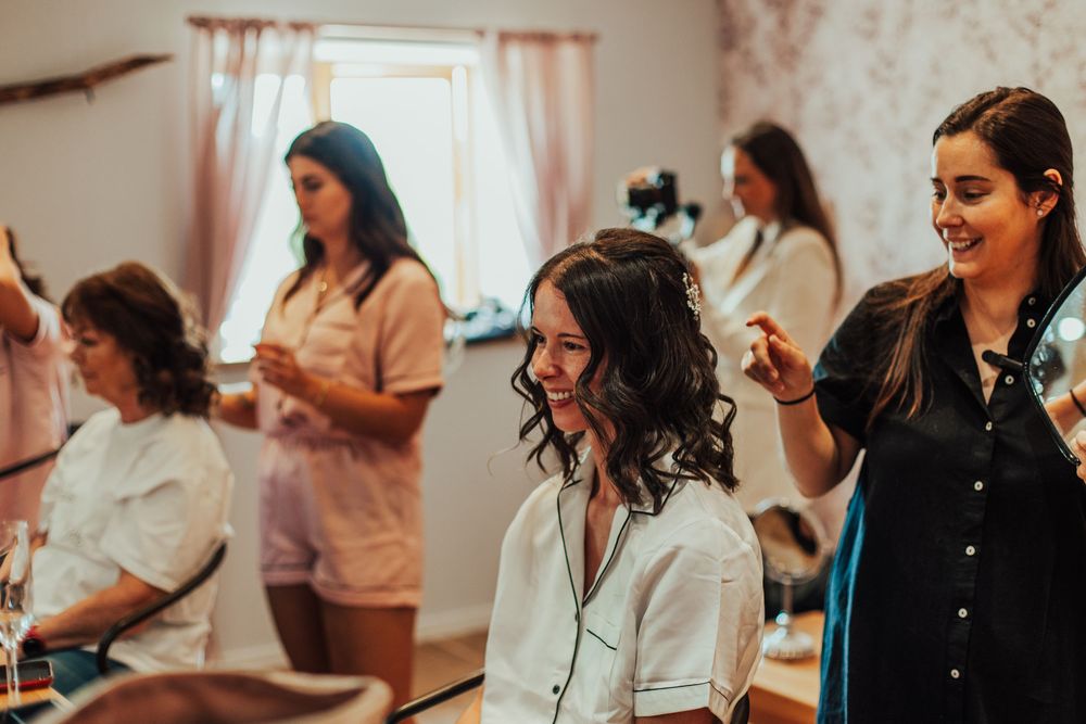 Group of women laughing and enjoying themselves at an indoor gathering with natural lighting.