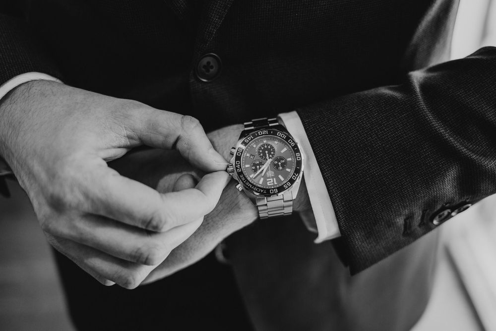 A wristwatch is being fastened onto someone's wrist in a series of close-up shots.