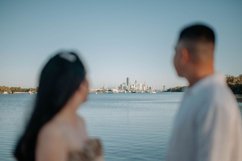 A couple gazes at the Seattle skyline across the calm waters of Lake Union on a sunny afternoon.