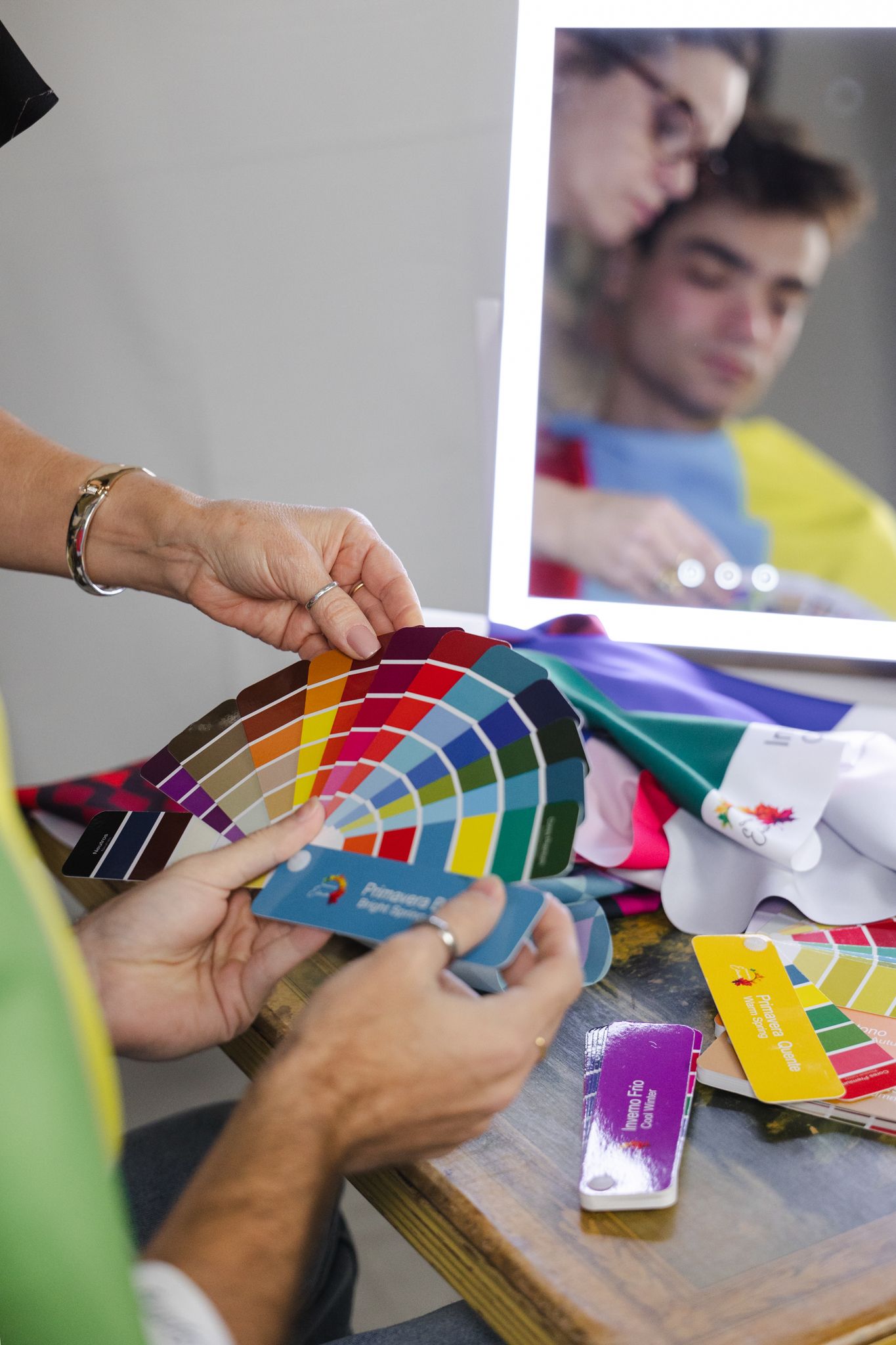 Designer holding color swatch samples and looking at paint swatches while working on interior design project.