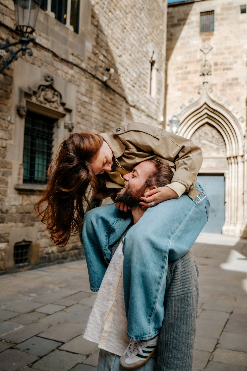The couple standing under soft light with Cathedral towers in the distance.