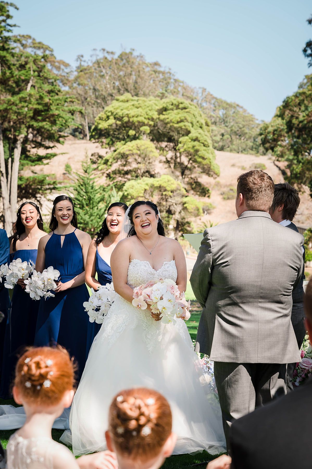 Blue welcome sign at outdoor wedding ceremony asking guests to turn off phones and cameras for an unplugged celebration.