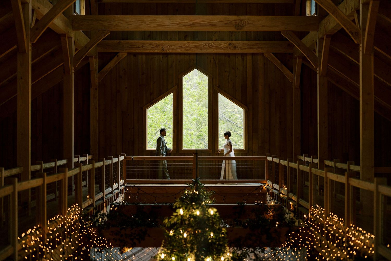 Rustic wooden barn interior with glowing lights and a window silhouetting figures at Windham Manor in Windham, New York.