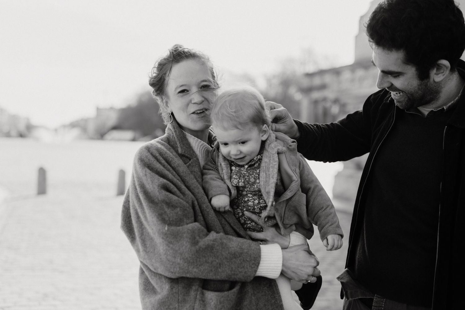 Black and white photo of family sharing joyful moment outdoors.