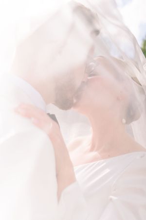 Bright close-up of bride and groom kissing beneath a flowing veil in The Park Estate, Nottingham, during their intimate elopement.