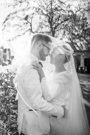 Black and white photo of bride and groom gazing into each other’s eyes under the veil in Nottingham’s Arboretum Park.
