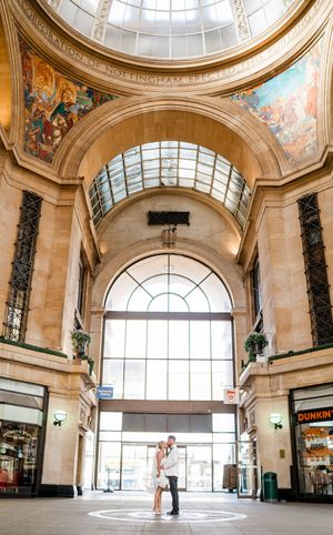 Bride and groom standing beneath the grand skylight of Nottingham Council House, framed by gothic arches and natural light.
