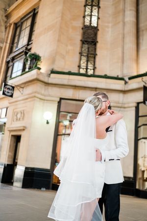 Couple walking outside the gothic Hopkins Solicitors building in Nottingham city centre, hand in hand, framed by red brick and historic char