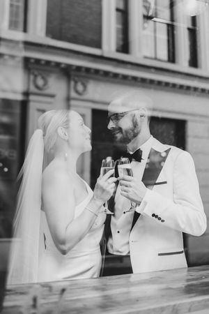 Close-up of groom holding a champagne glass, wedding ring visible, at their reception in Table 47, Lace Market, Nottingham.
