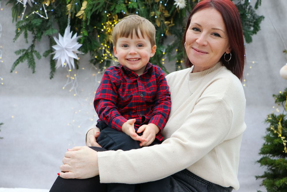 Winter portrait with cozy sweaters against festive Christmas tree background.
