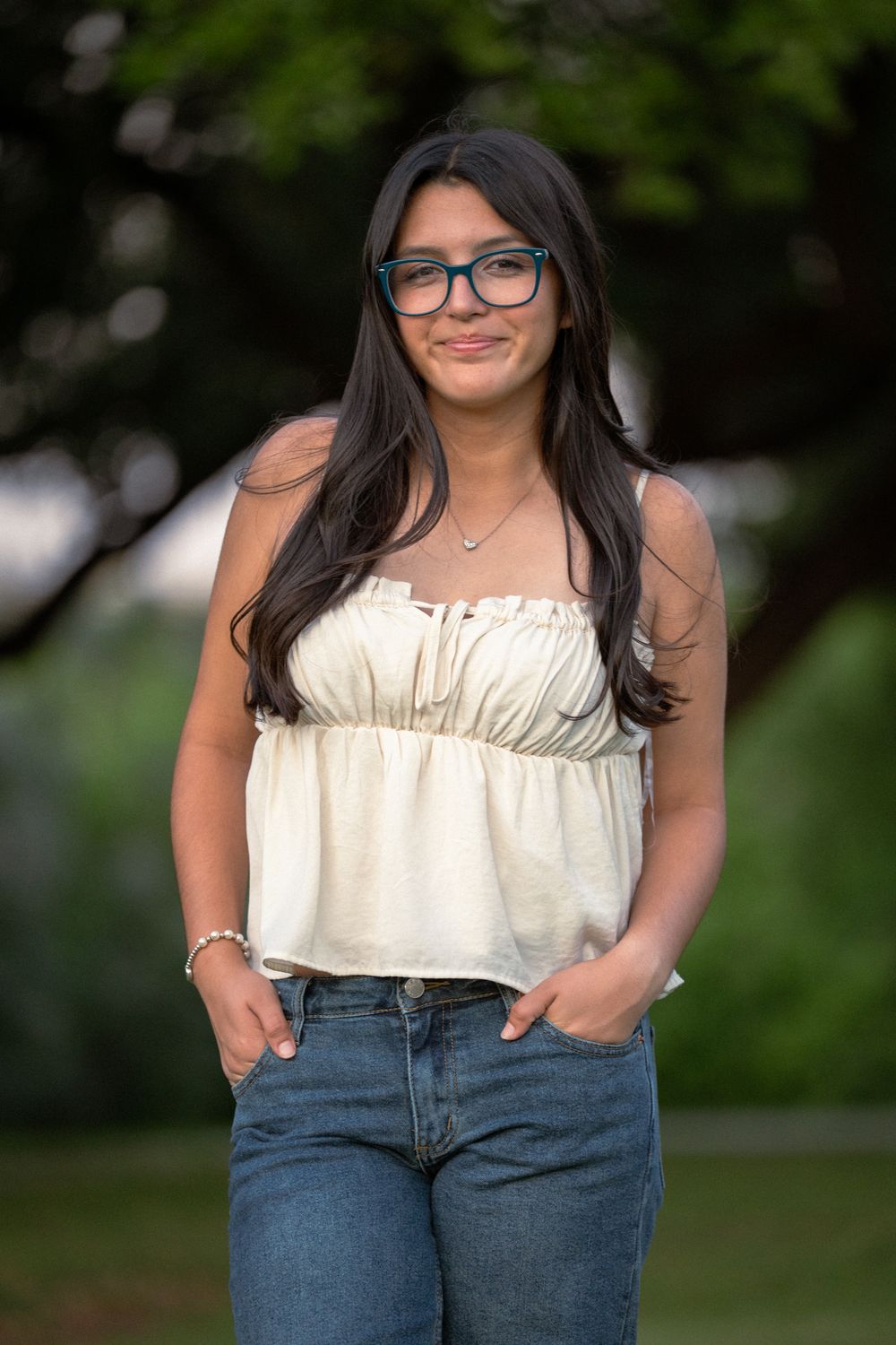A series of casual outdoor portraits showing someone wearing a white sleeveless top and blue jeans against a natural background.