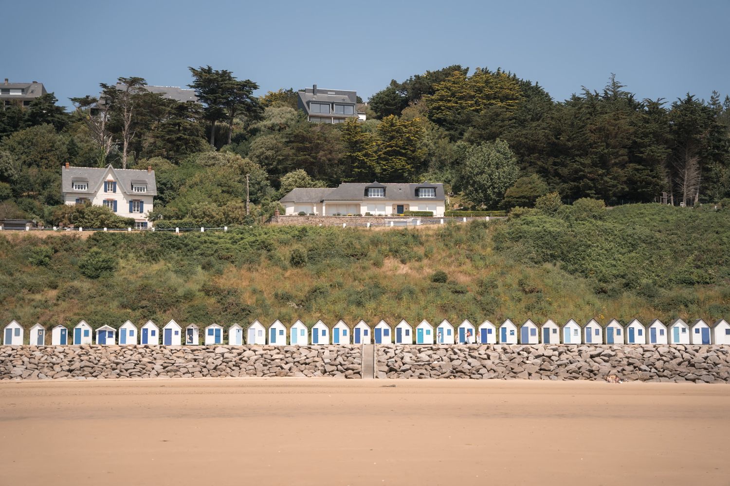 Plage de la Potinière avec ses cabines blanches et bleues dans le département de la Manche en Normandie - Cotentin.
