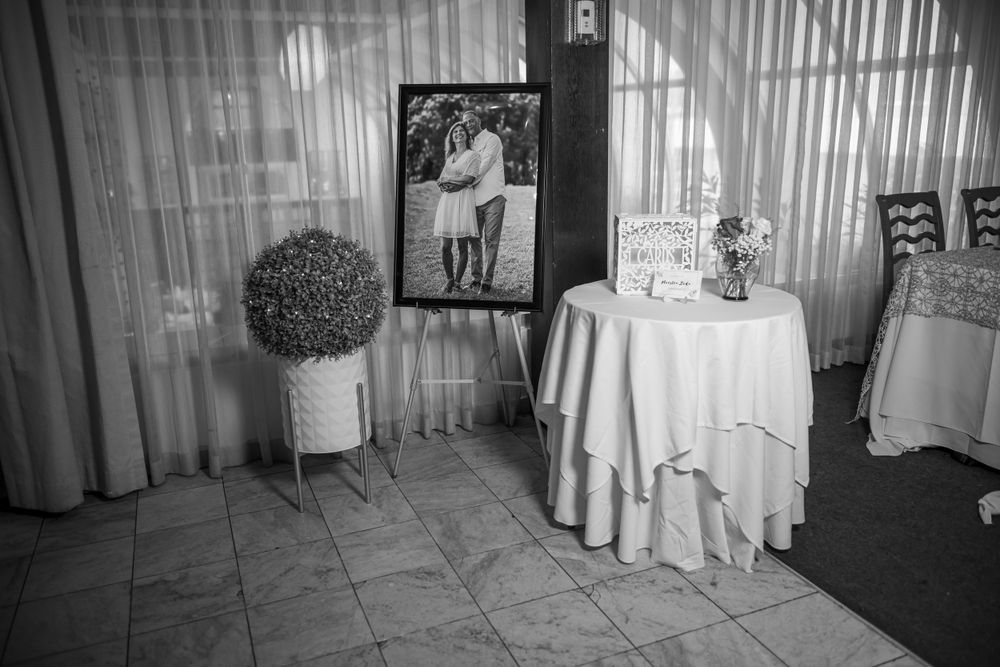 Black and white vintage wedding photo display with round tables and decor.