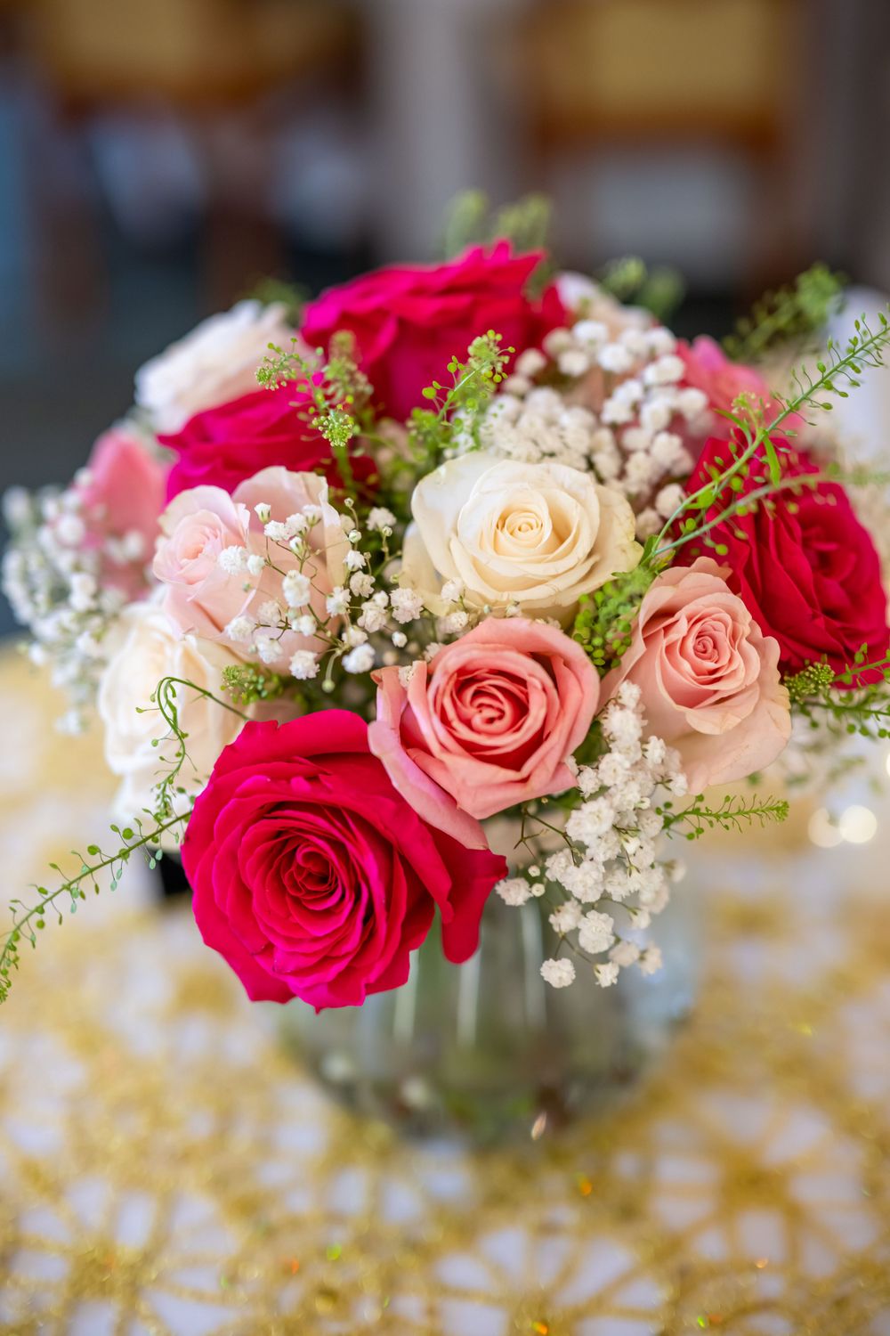 Beautiful bouquet of pink and red roses with baby's breath in glass vase.