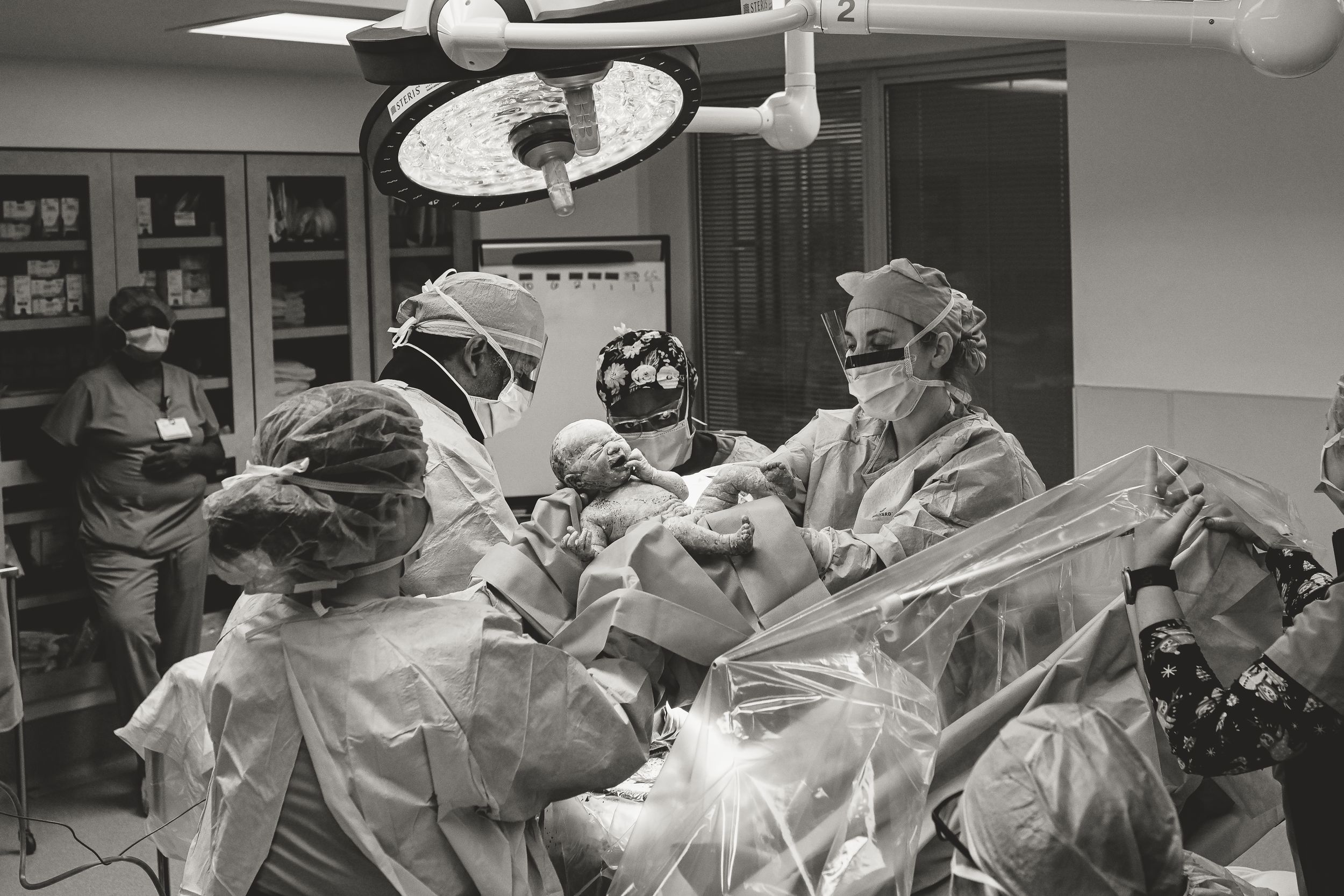 Birth photographer captures baby girl being born in the operating room via cesarean section at St. Thomas in Nashville, Tennessee.