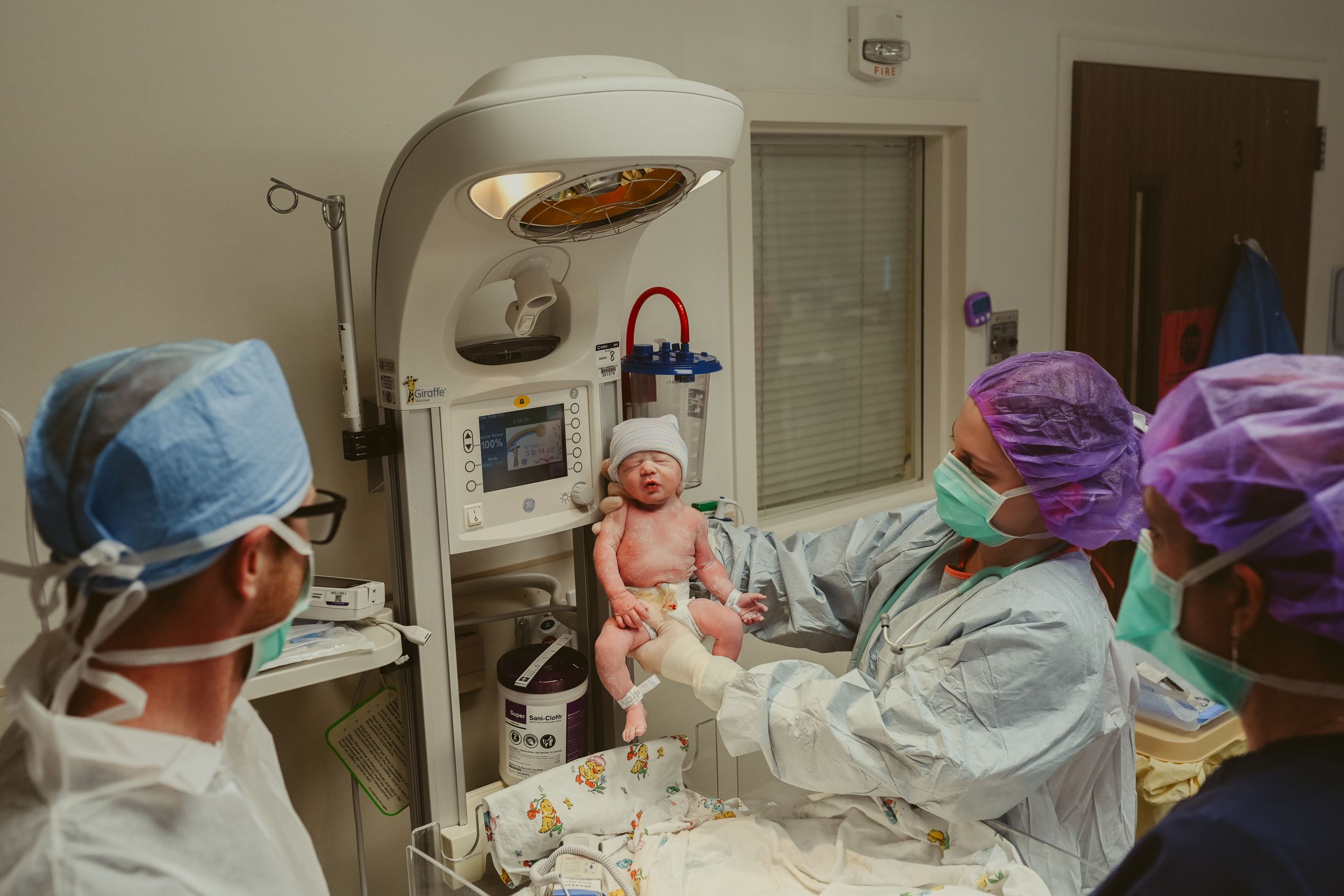 Nurse proudly holds up newborn baby girl in the operating room post cesarean section at St. Thomas in Nashville, Tennessee.