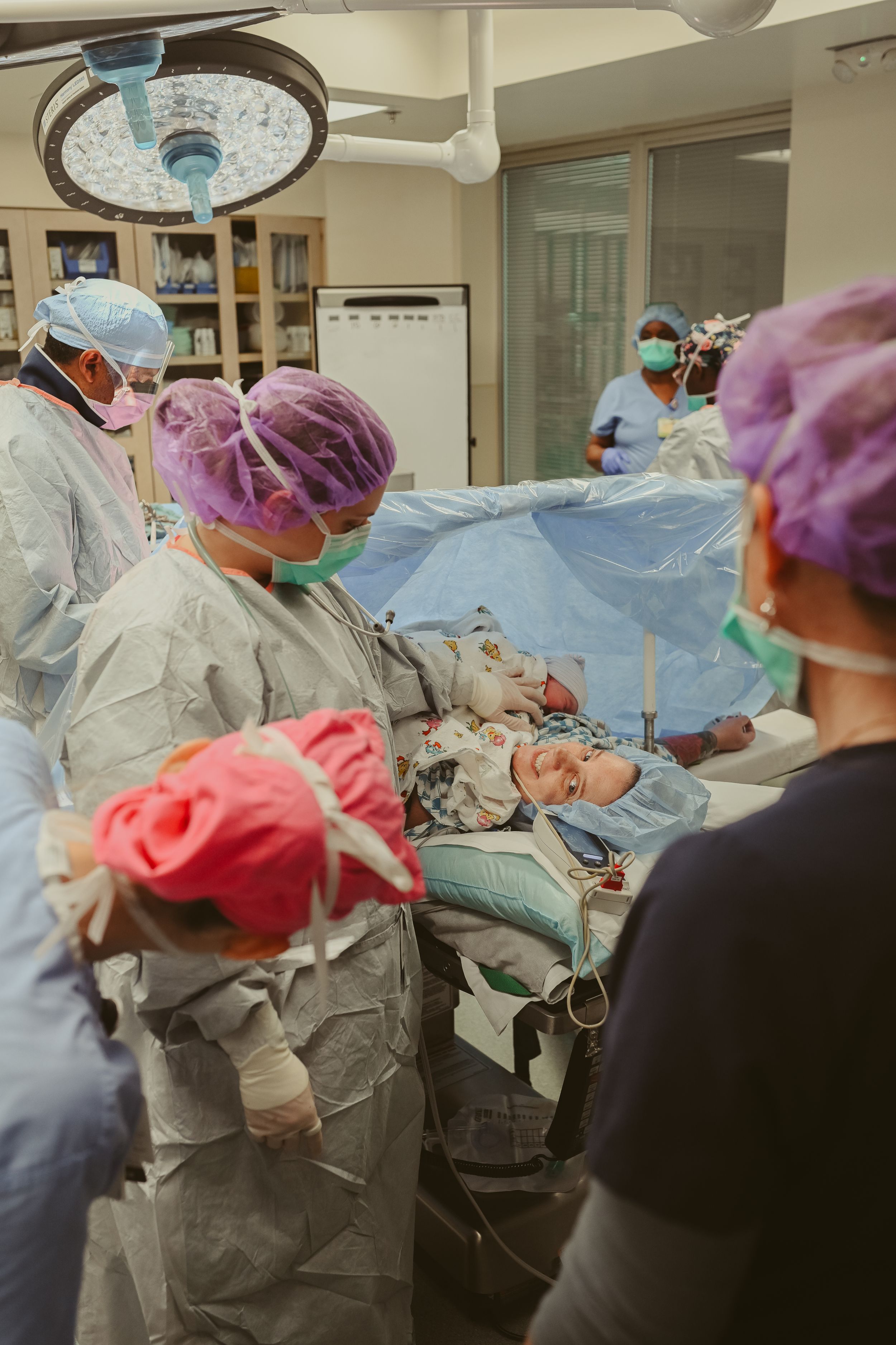 New mom sees newborn baby girl for the first time in the operating room post cesarean section at St. Thomas in Nashville, Tennessee.