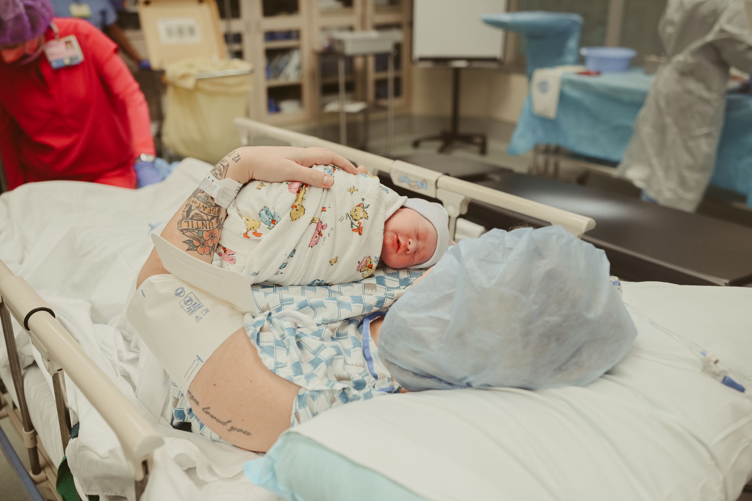 Mom is wheeled out of operating room on bed with newborn baby girl on her chest post cesarean section at St. Thomas in Nashville, Tennessee.