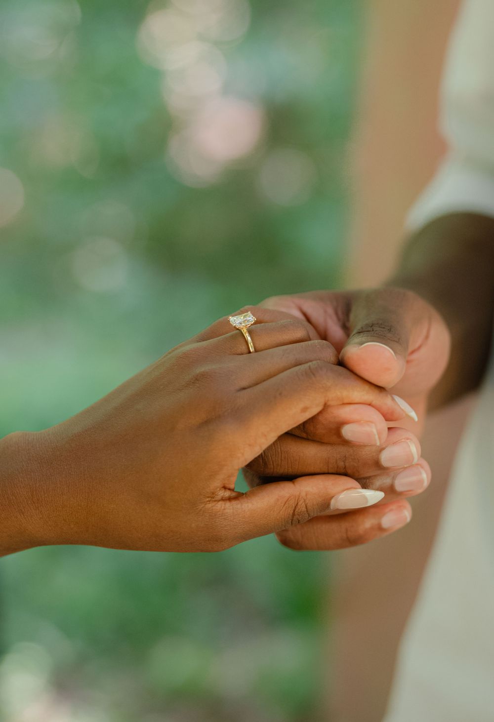 detail shot of newly engaged couple holding hands showing off the ring