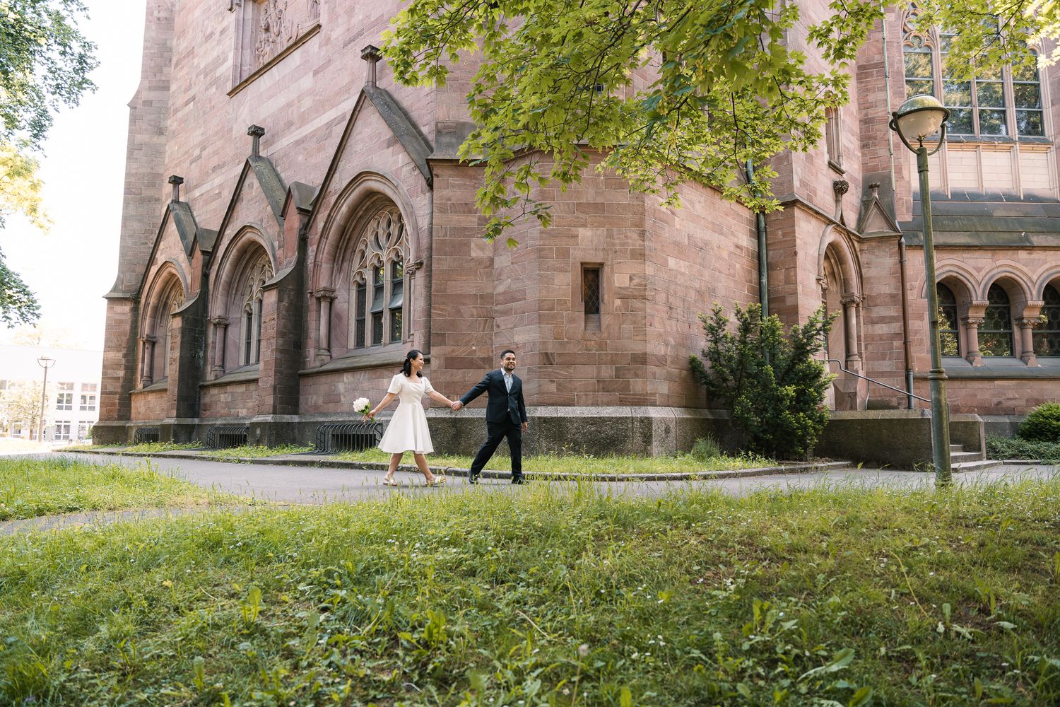 Paar spaziert vor einer Kirche in Karlsruhe vor ihrer Hochzeit