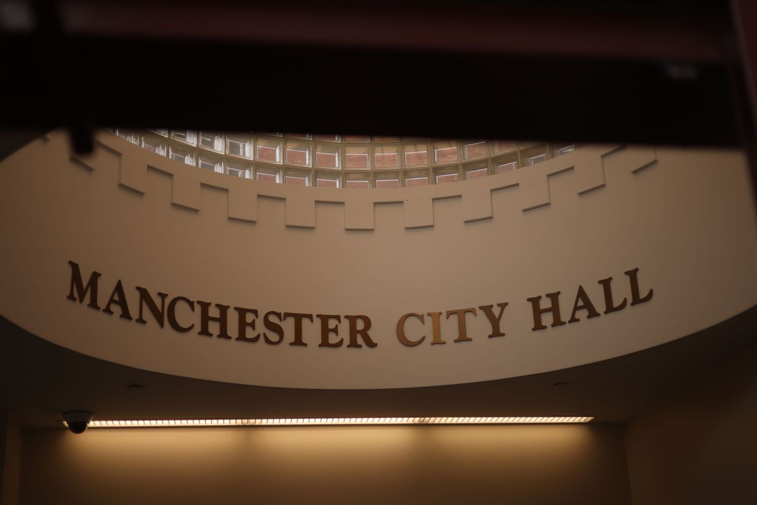 Manchester City Hall illuminated sign with elegant decorative border in warm golden light.
