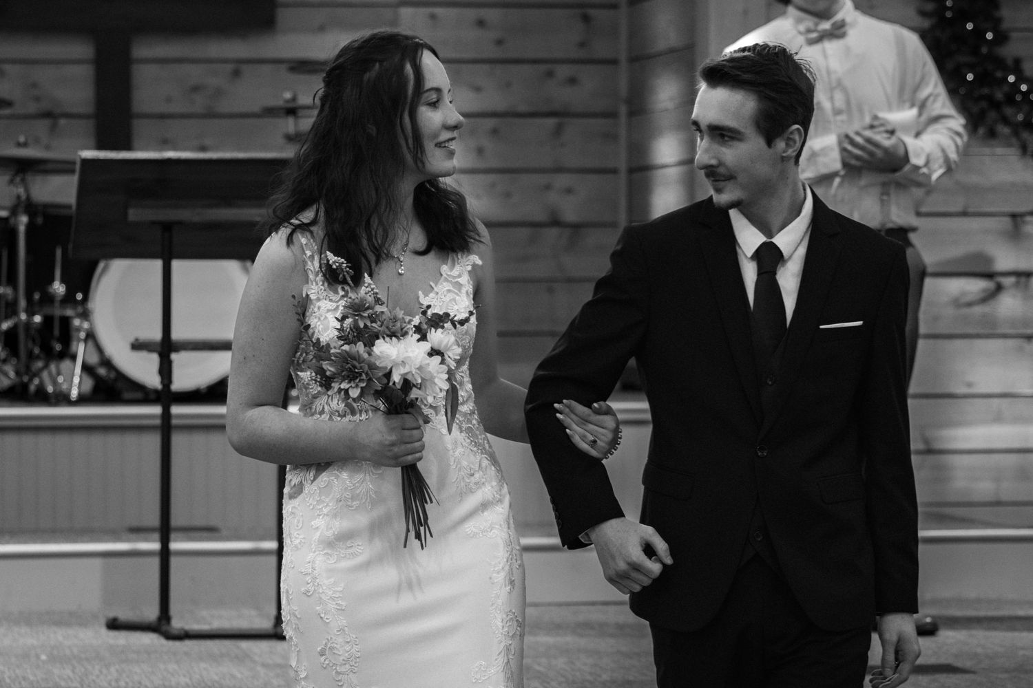 Happy bride and groom walking down the aisle together in a classic black and white wedding photo.