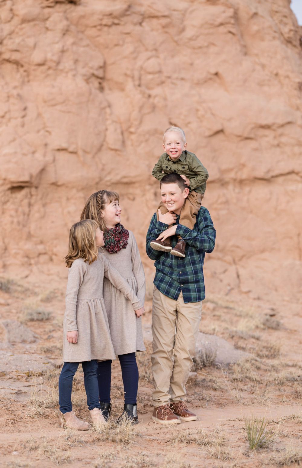 A joyful family moment captured against a towering desert cliff face.