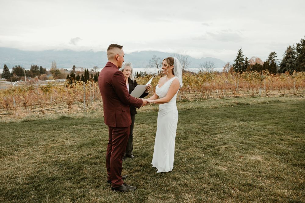 bride and groom smiling and looking at one another during ceremony at gorgeous winery In west kelowna bc