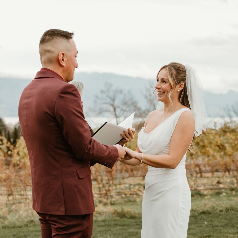 bride looking at groom during elopement ceremony at mt boucherie winery in west kelowna bc, beautiful mountain and lake views