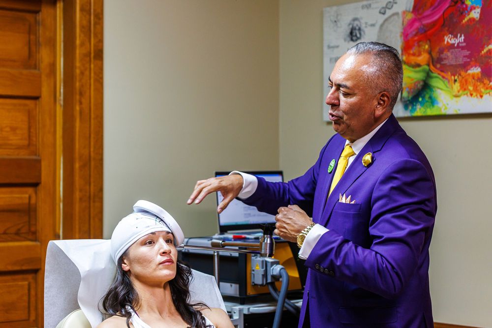 Doctor in purple suit performing neurological assessment on female patient in medical office setting.