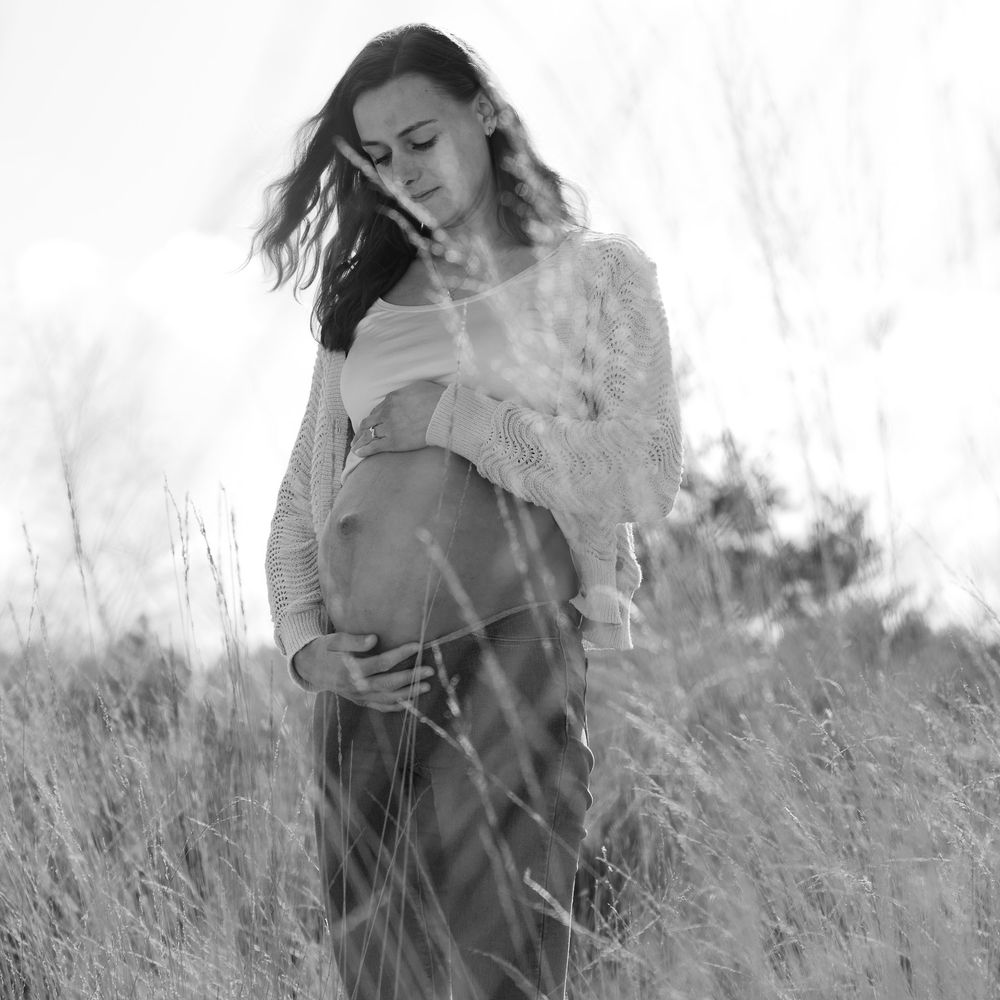 Zwart-wit foto van zwangere vrouw op de heide door het hoge gras - zwangerschapsshoot in de natuur - Sonse vennen - MaxFotos
