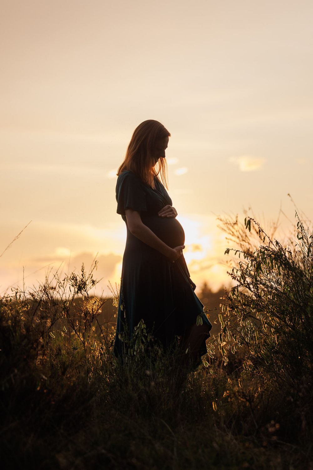 Silhouette van zwangere vrouw bij magische zonsondergang in tegenlicht - zwangerschapsshoot in de natuur - Drenthe - MaxFotos
