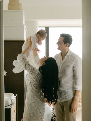 Loving parents lifting and admiring their baby in a bright modern home interior.