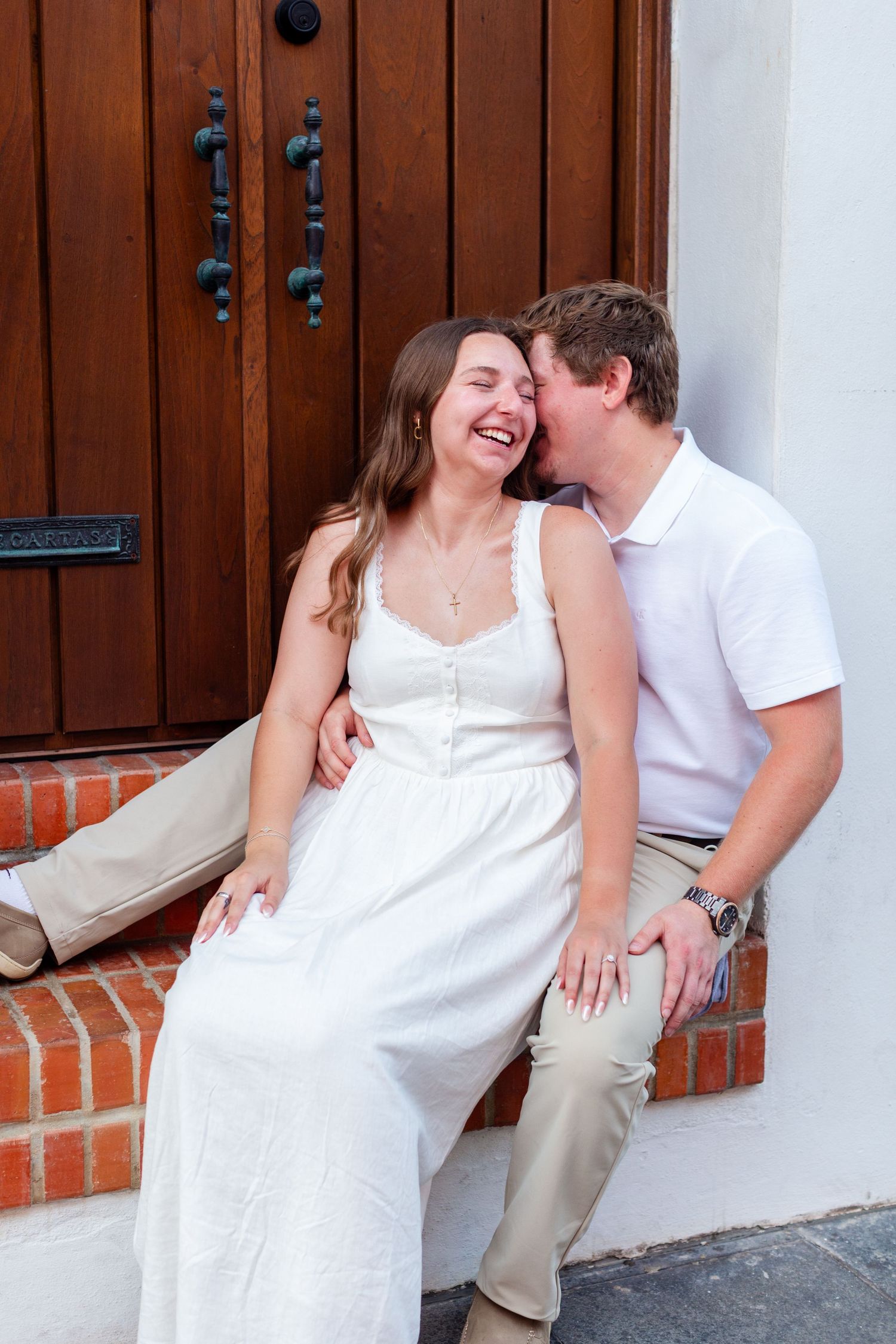 Couples portrait seated in a doorway. Engagement photo session in Old San Juan, Puerto Rico.