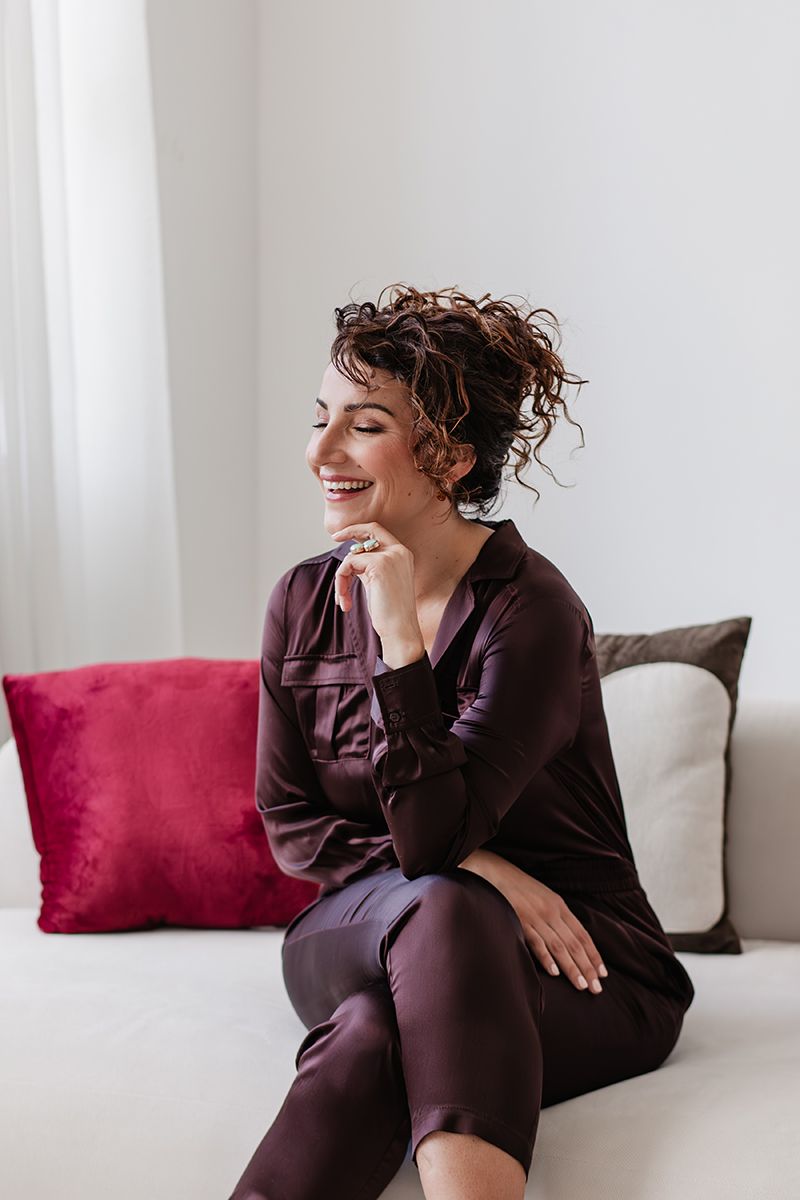 Personal branding shoot met en vrouwelijke makelaar met lichte tinten en bordeaux rood en paarse kleuren.