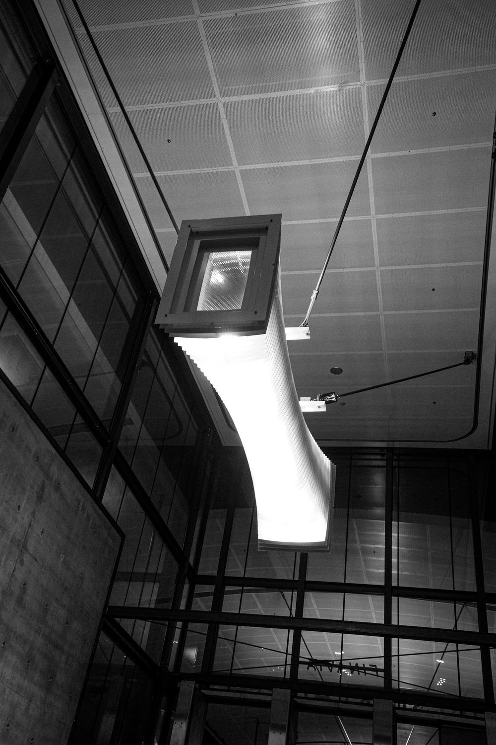 Black and white photo of a Helsinki Airport railway station concourse.