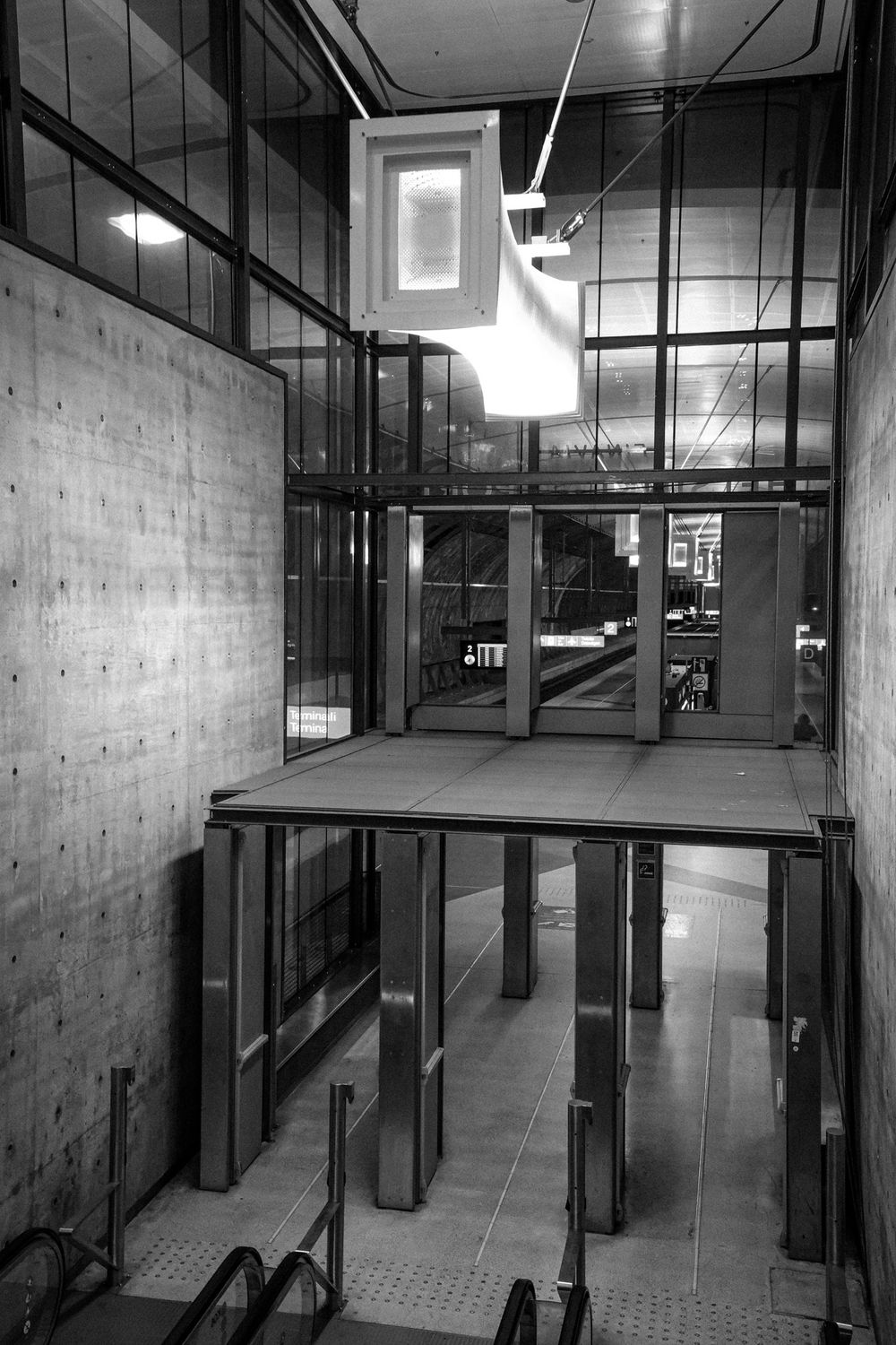 Black and white photo of a Helsinki Airport railway station concourse.