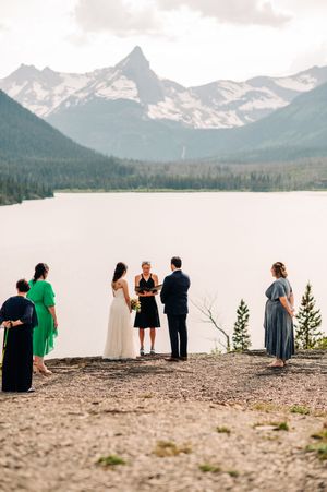 Small intimate wedding ceremony overlooking a mountain lake with snowy peaks.