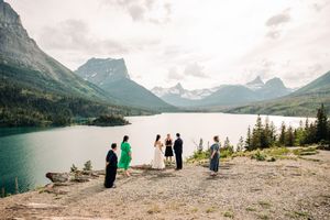 Small intimate elopement ceremony on rocky overlook above stunning turquoise mountain lake.