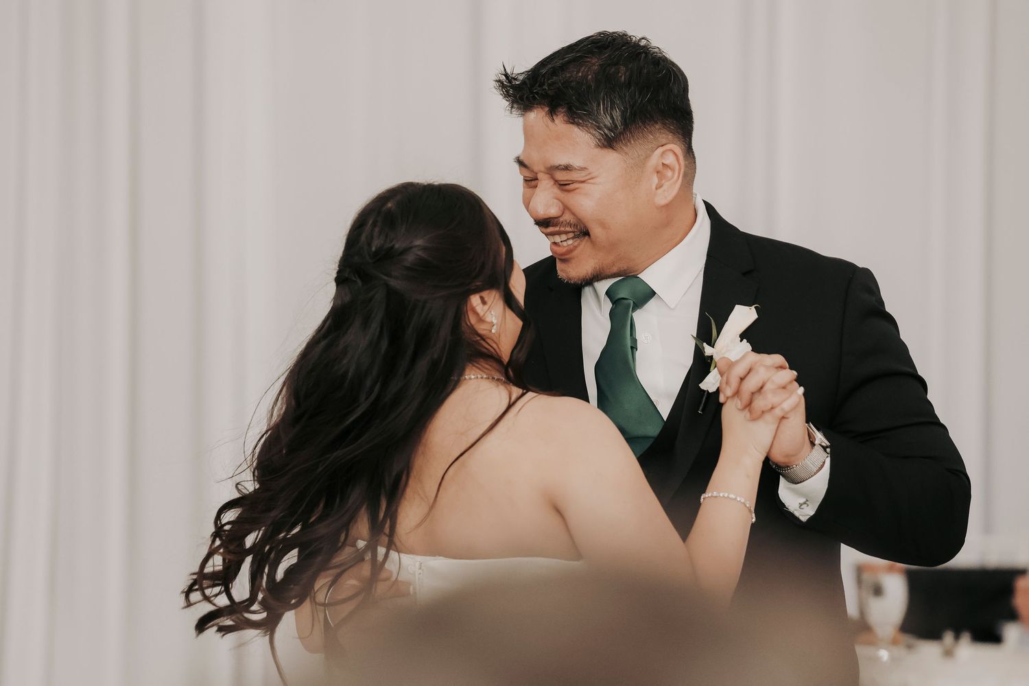 a happy daddy daughter dance between the bride and her father