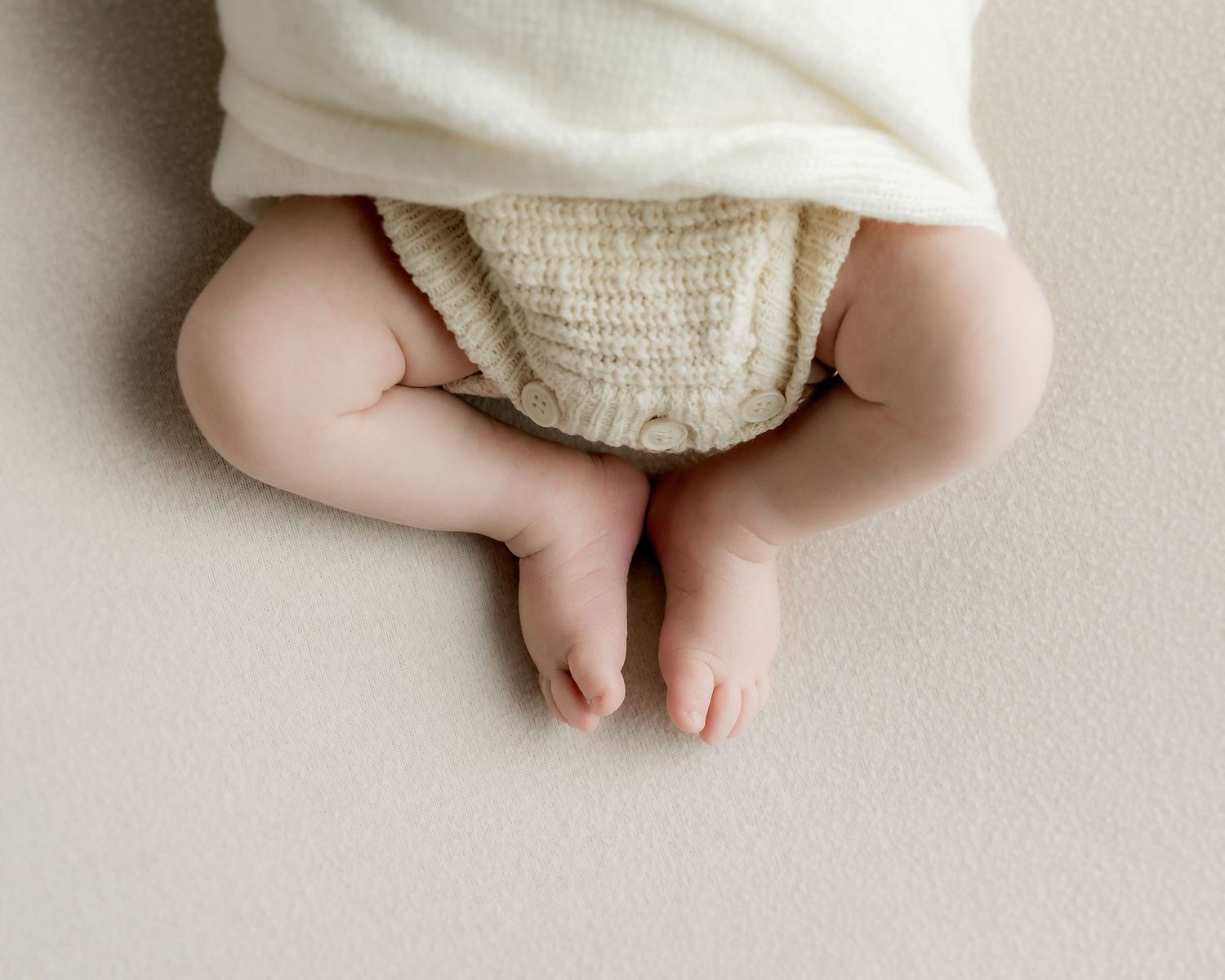 Newborn baby wrapped in handmade knit outfit