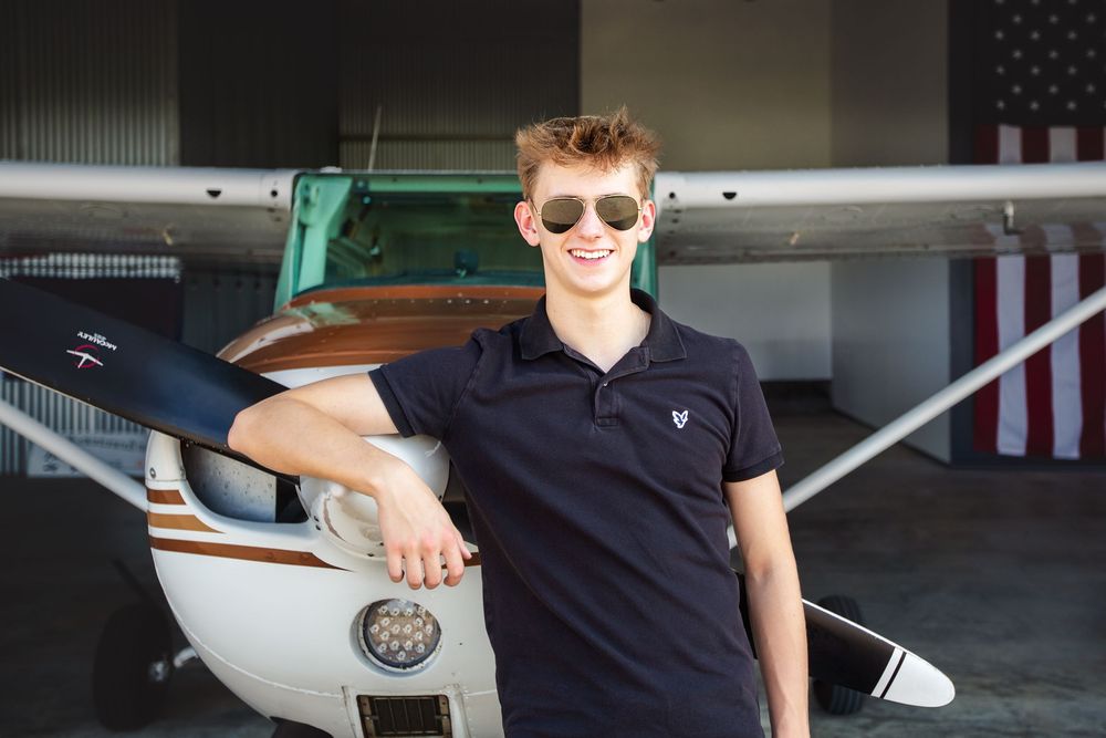 Creative senior guy portraits; pilot-inspired senior pictures at a private airport near Ann Arbor Michigan