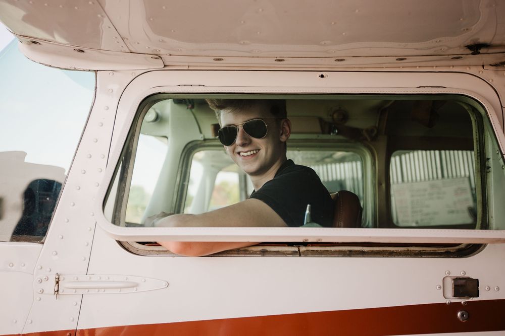 Creative senior guy portraits; pilot-inspired senior pictures at a private airport near Ann Arbor Michigan