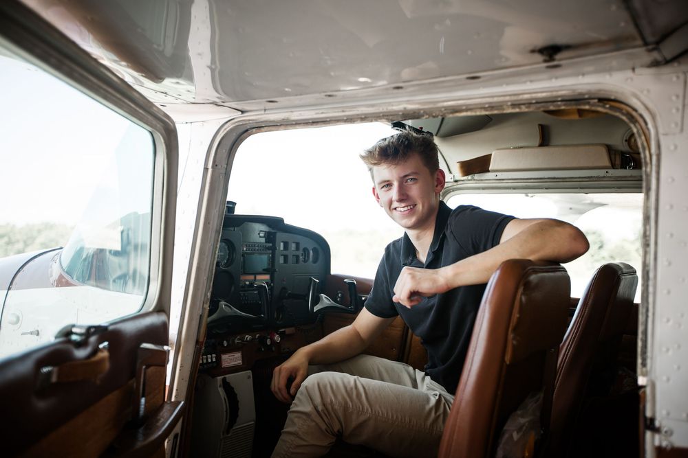 Creative senior guy portraits; pilot-inspired senior pictures at a private airport near Ann Arbor Michigan