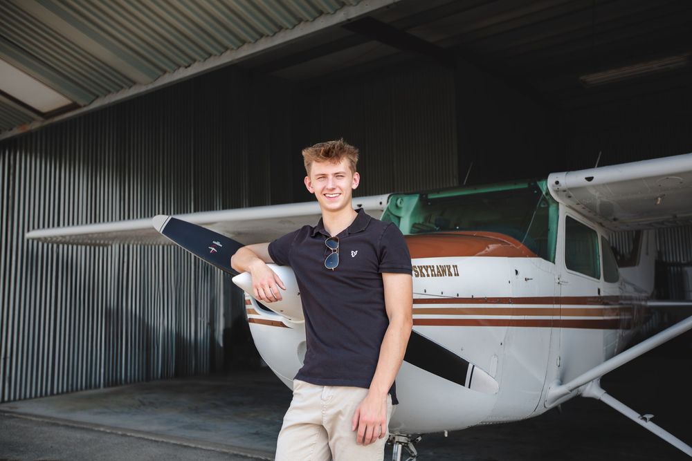 Creative senior guy portraits; pilot-inspired senior pictures at a private airport near Ann Arbor Michigan